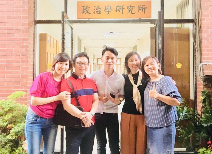 徐暄景老師與政治所學會會長（中間）及其他所友們於系所大門口前合影。圖片
