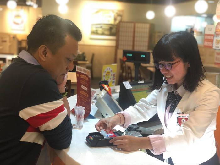 於櫃台進行結帳工作　適時與客戶進行互動（林鈺欣　提供）圖片