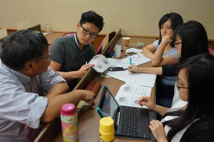 張紹堯與同學討論企劃書的內容（中山大學企管系  提供）圖片